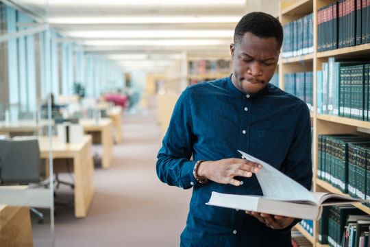 Student reading book in library